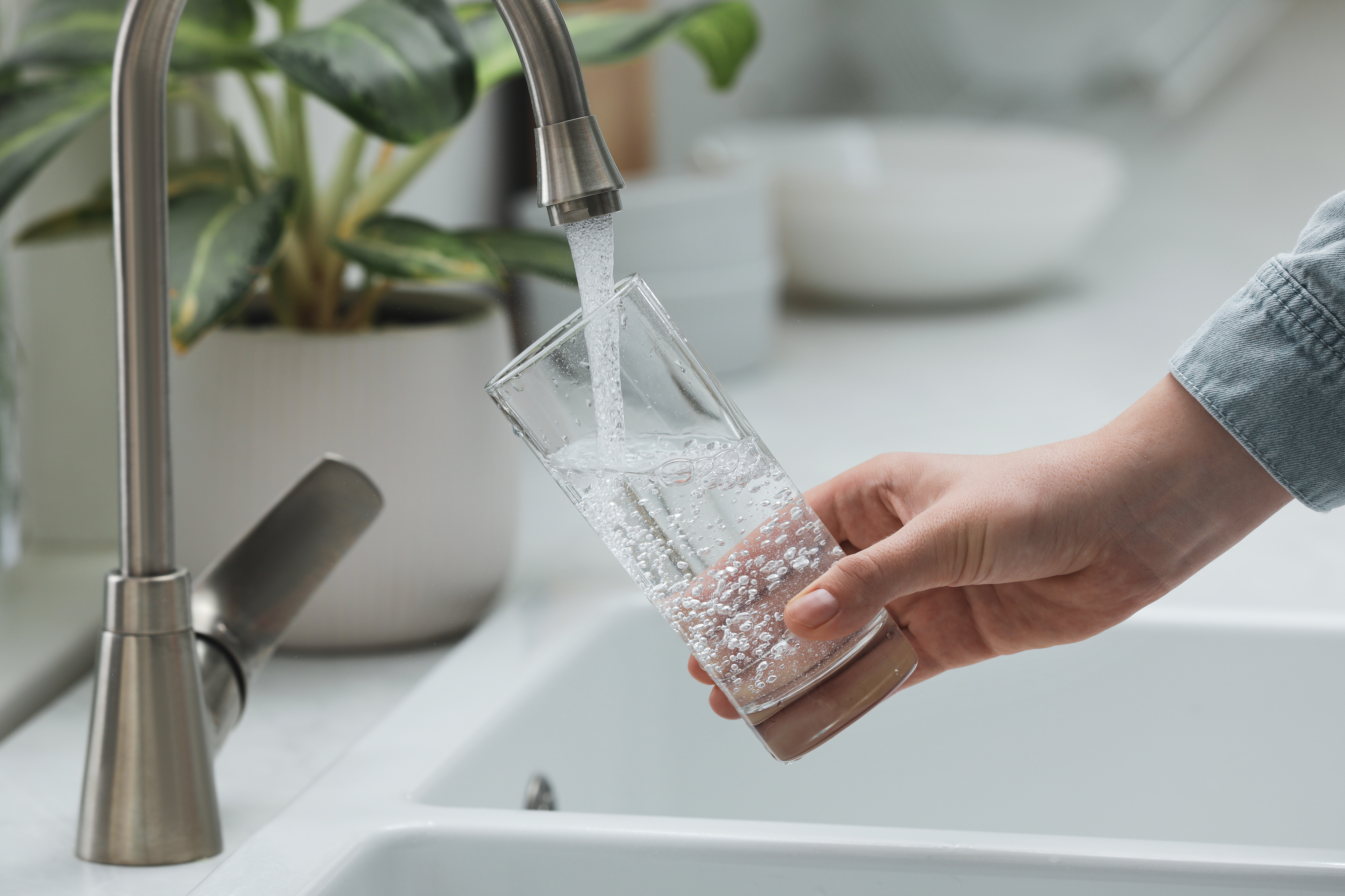 Filling glass with pure filtered water from tap