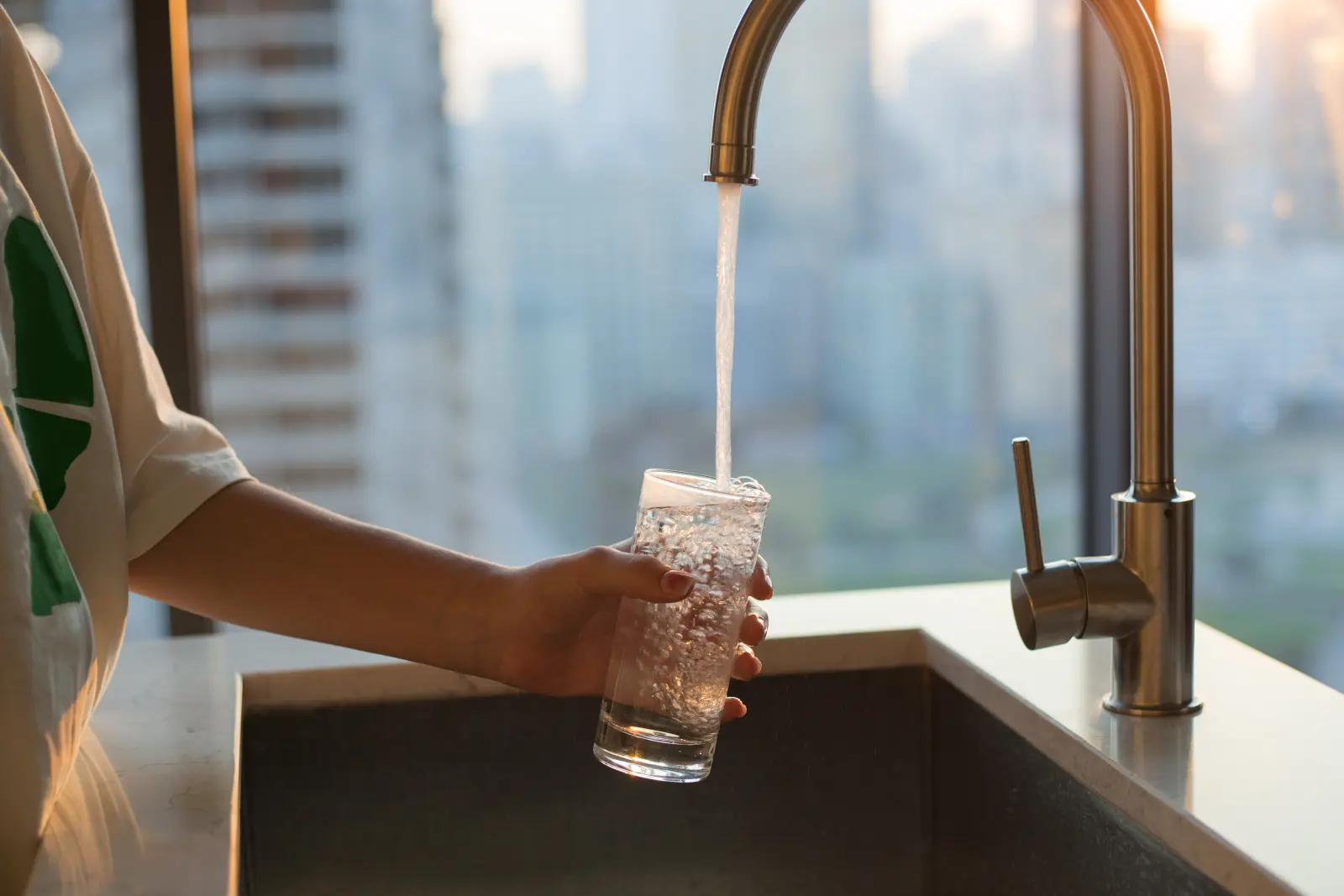 Glass being filled at a kitchen faucet