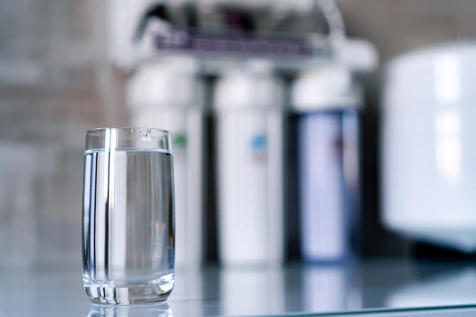 A glass of water in front of reverse osmosis filters